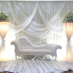 Stylish couch with a white backdrop and custom-made lamps by Makkah Decorators, creating an elegant setting for events in Melbourne.