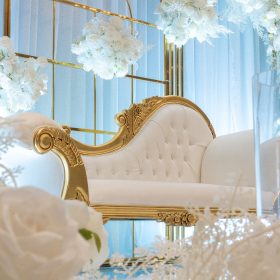 Luxurious sitting couch on stage with elegant decor by Makkah Decorators for a stylish Melbourne event.