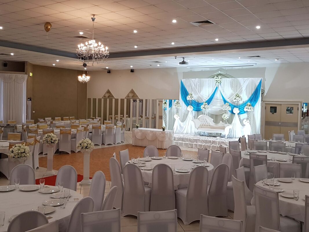 Wedding hall with white and light blue backdrop on the stage