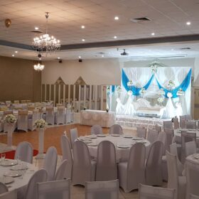 Wedding hall with white and light blue backdrop on the stage