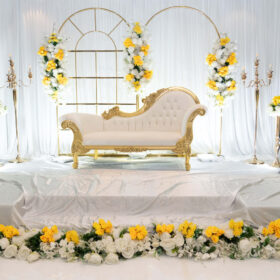 Stage decor with white and gold with some white and yellow flowers